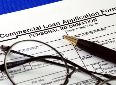 commercial loan application with a pen and glasses