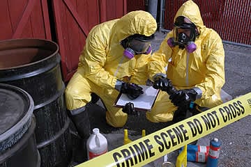 two people in yellow haz-mat suits at a meth lab